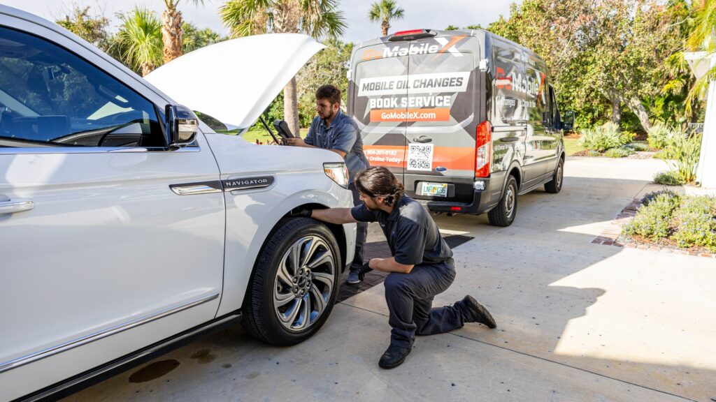 two technicians working on a car